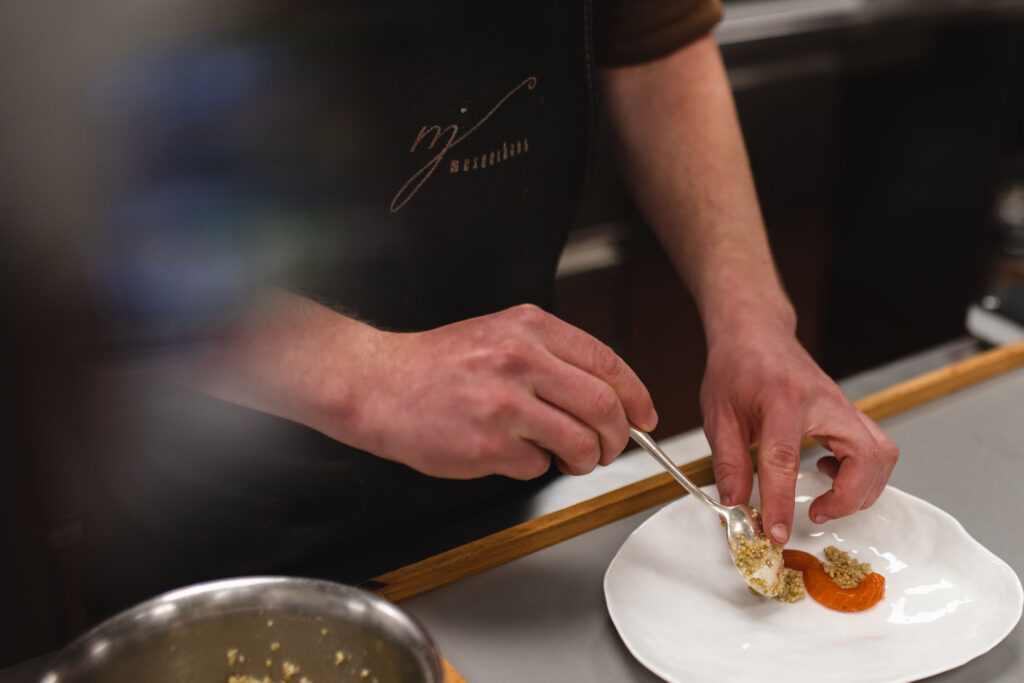 Koch richtet einen Teller im Mesnerhaus Gourmet-Restaurant an