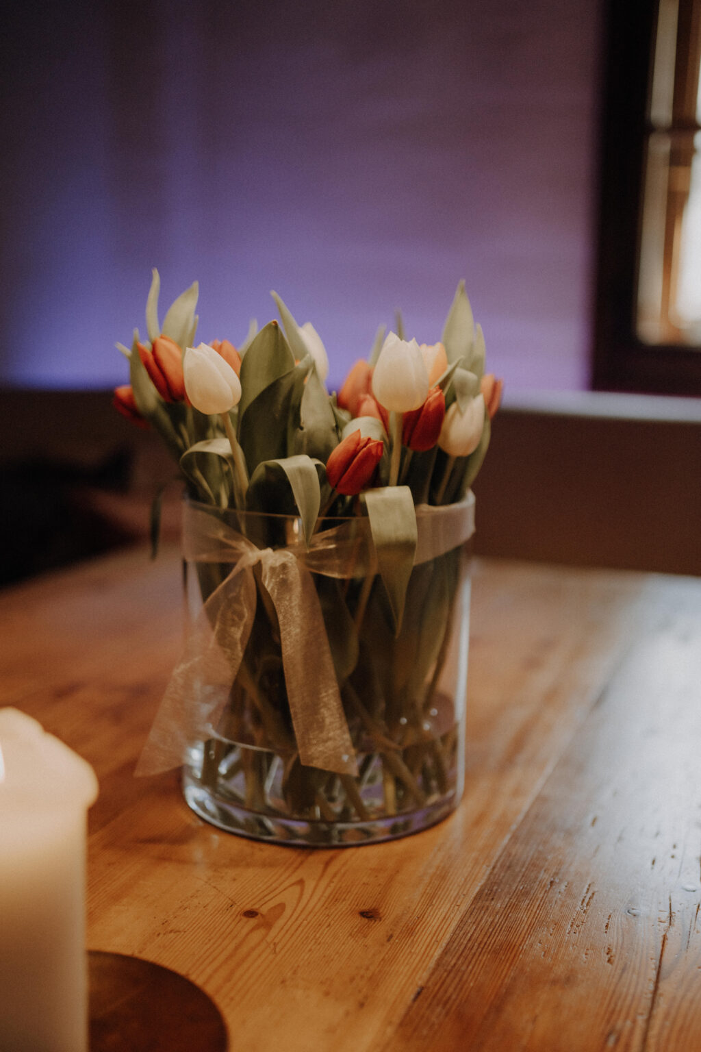 Tulpenstrau&szlig; in einer Glasvase auf einem Holztisch im Mesnerhaus