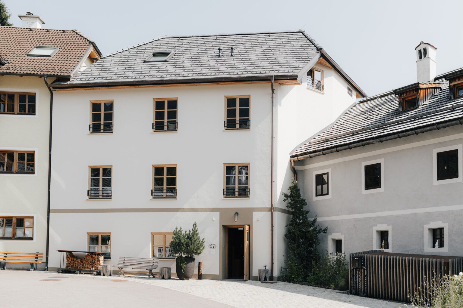 Au&szlig;enansicht des Mesnerhaus Boutique-Hotels mit wei&szlig;er Fassade und angrenzendem historischen Geb&auml;ude