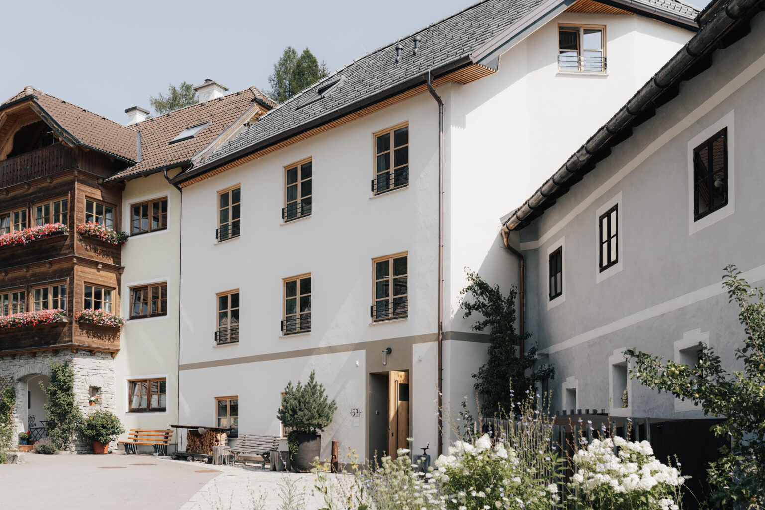 Mesnerhaus Boutique-Hotel im Innenhof mit wei&szlig;er Fassade und historischem Nachbargeb&auml;ude