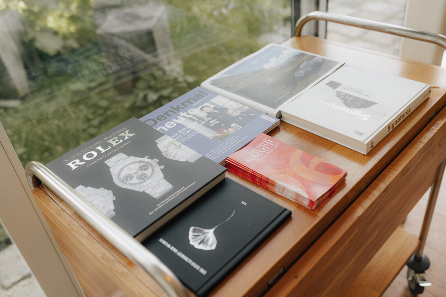 Auswahl an B&uuml;chern auf einem Holzwagen im Mesnerhaus