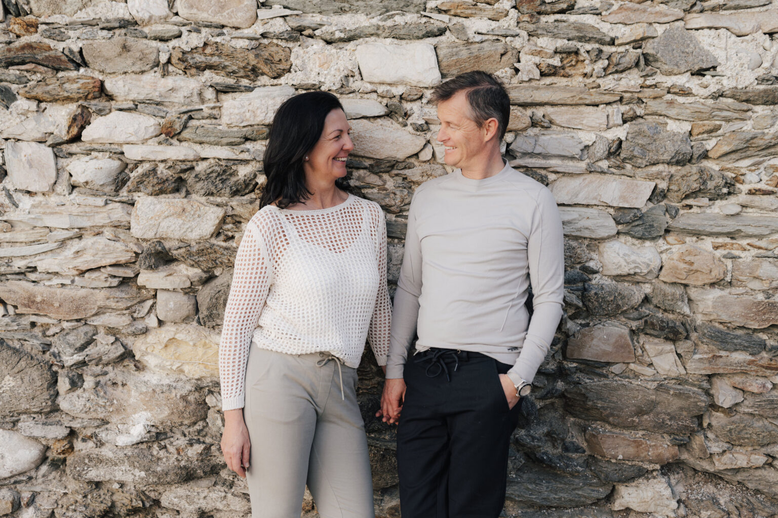 Maria und Josef Steffner Hand in Hand vor einer historischen Steinmauer