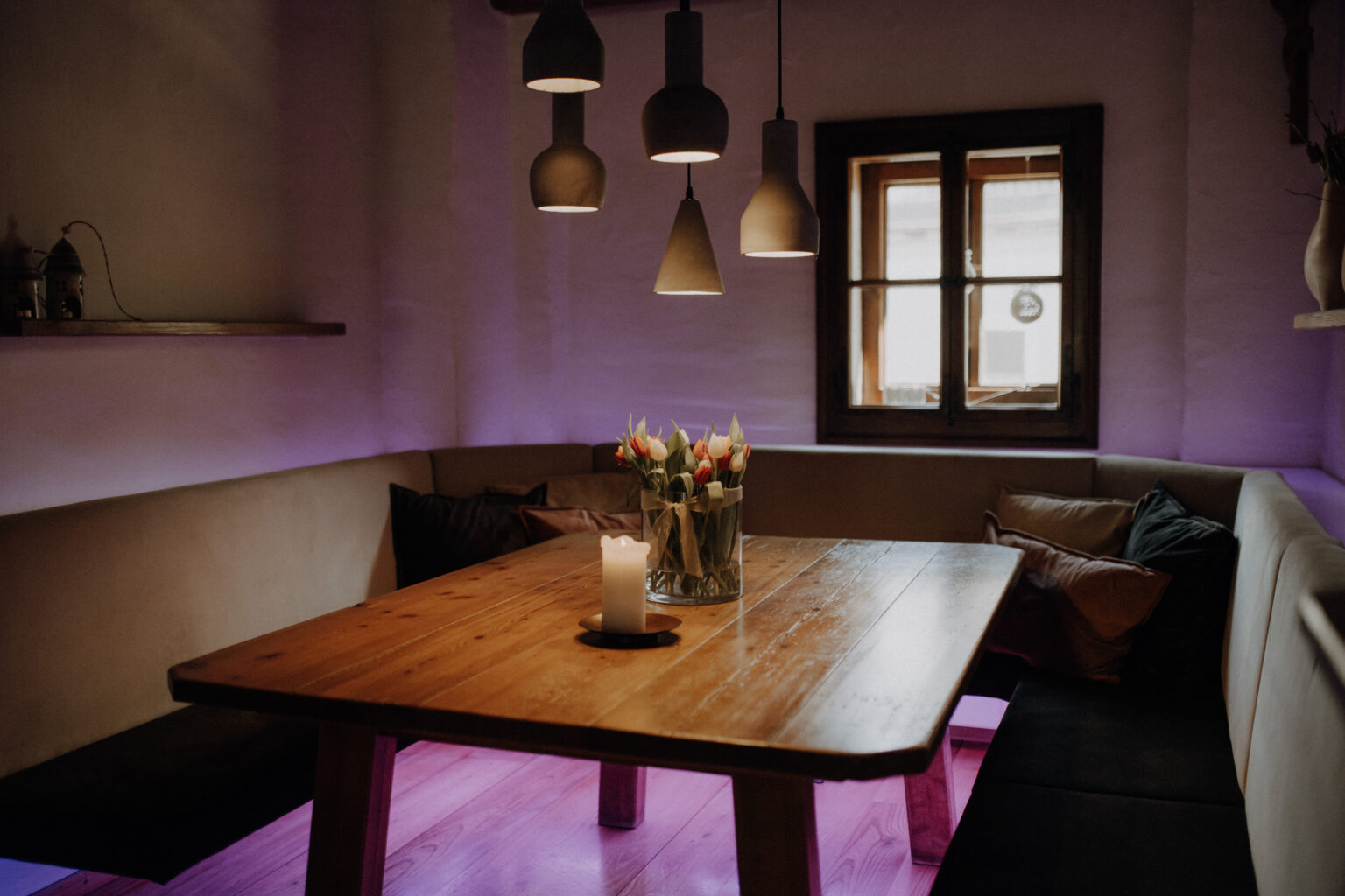 Stammtisch im Mesnerhaus mit Holztafel, Sitzbank und Pendelleuchten