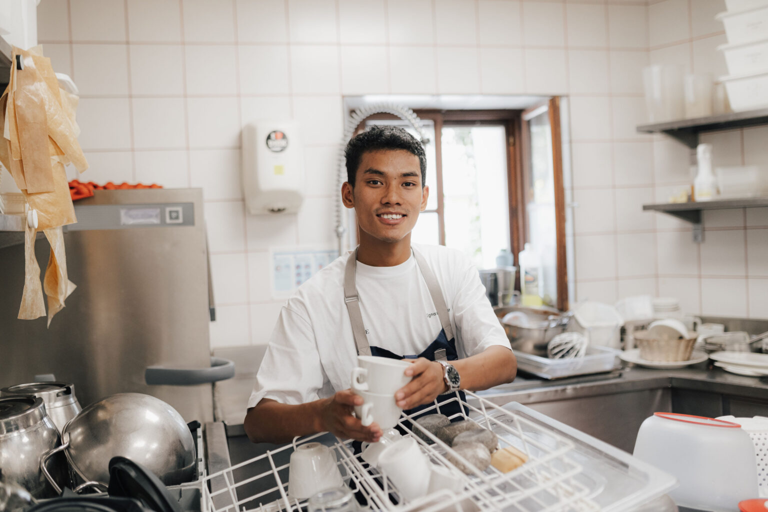 Steward Aagnima Sherpa bei einem Portr&auml;t am Sp&uuml;lbereich der Restaurantk&uuml;che