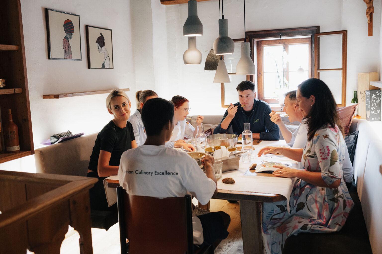 Das Mesnerhaus-Team gemeinsam beim Essen an einem Tisch im Restaurant