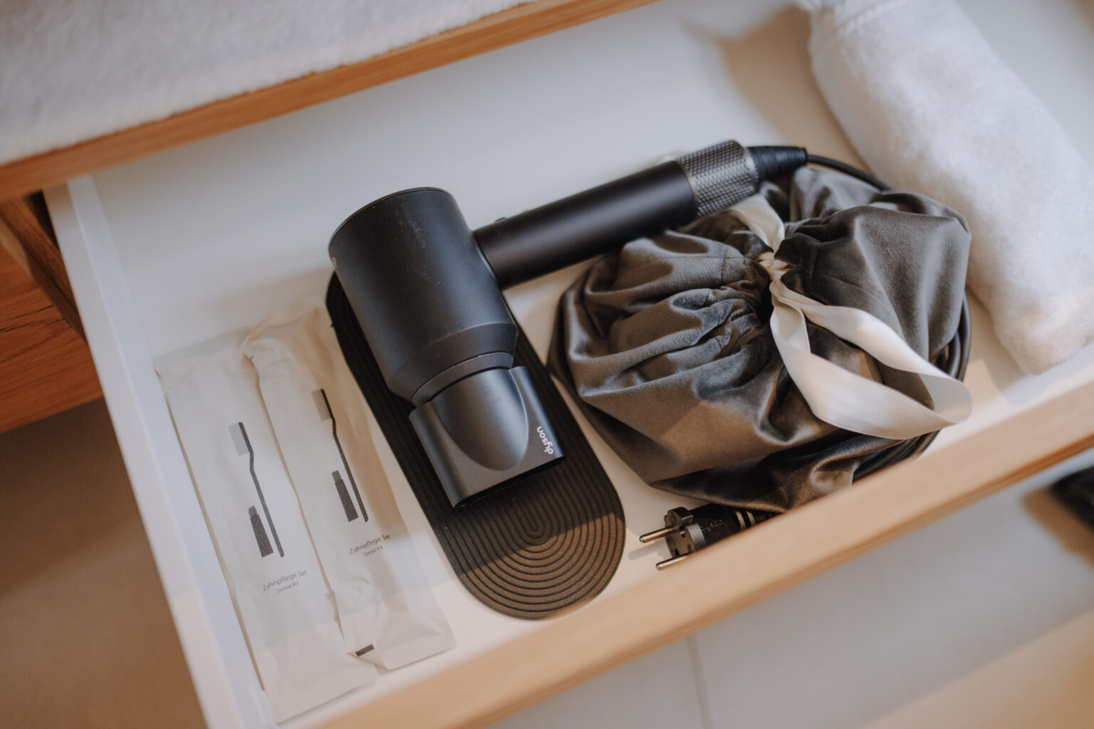 F&ouml;hn und Hotelzubeh&ouml;r in einer ge&ouml;ffneten Schublade im Mesnerhaus Boutique-Hotel