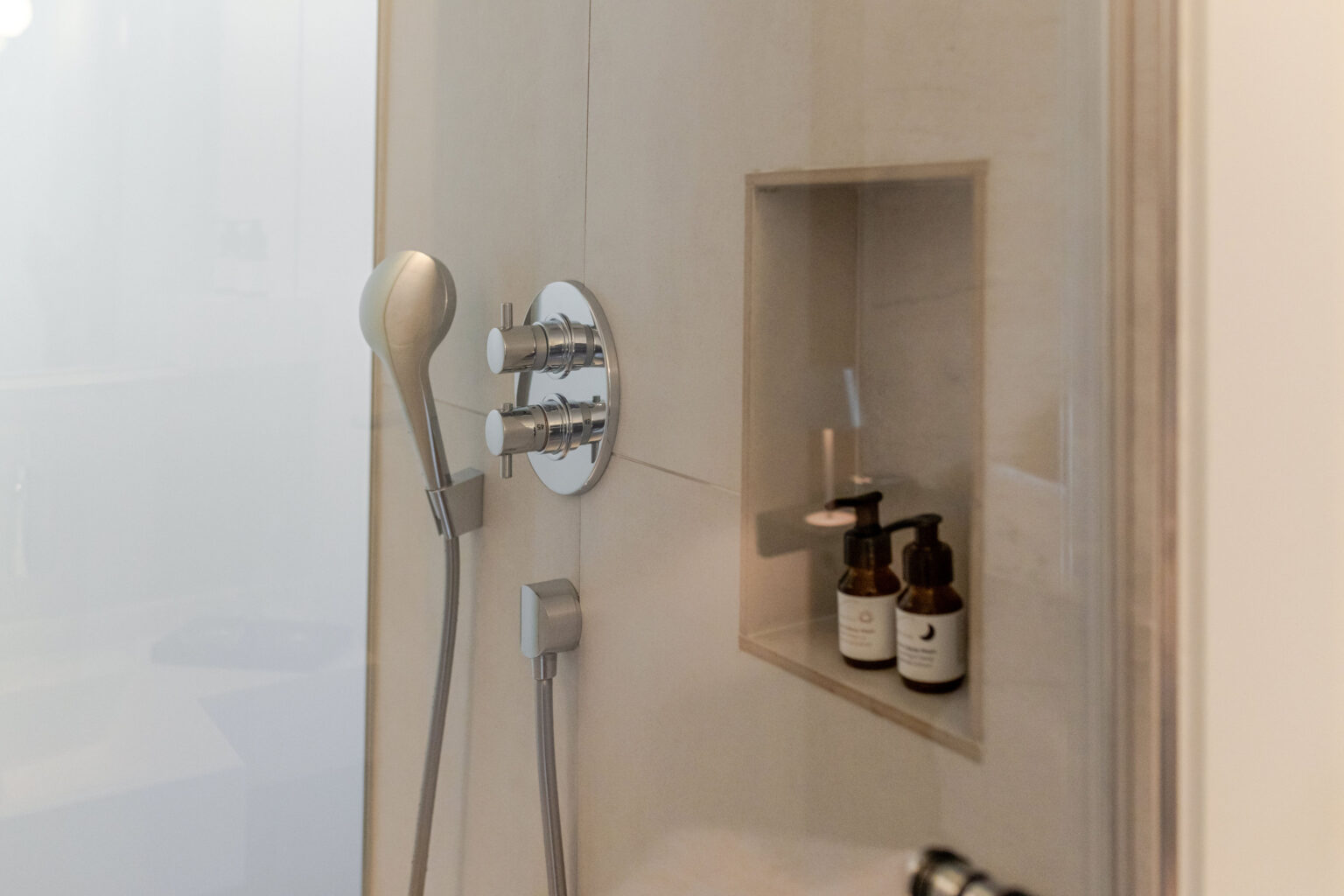 Dusche mit Handbrause und Pflegeprodukten im Mesnerhaus Boutique-Hotel